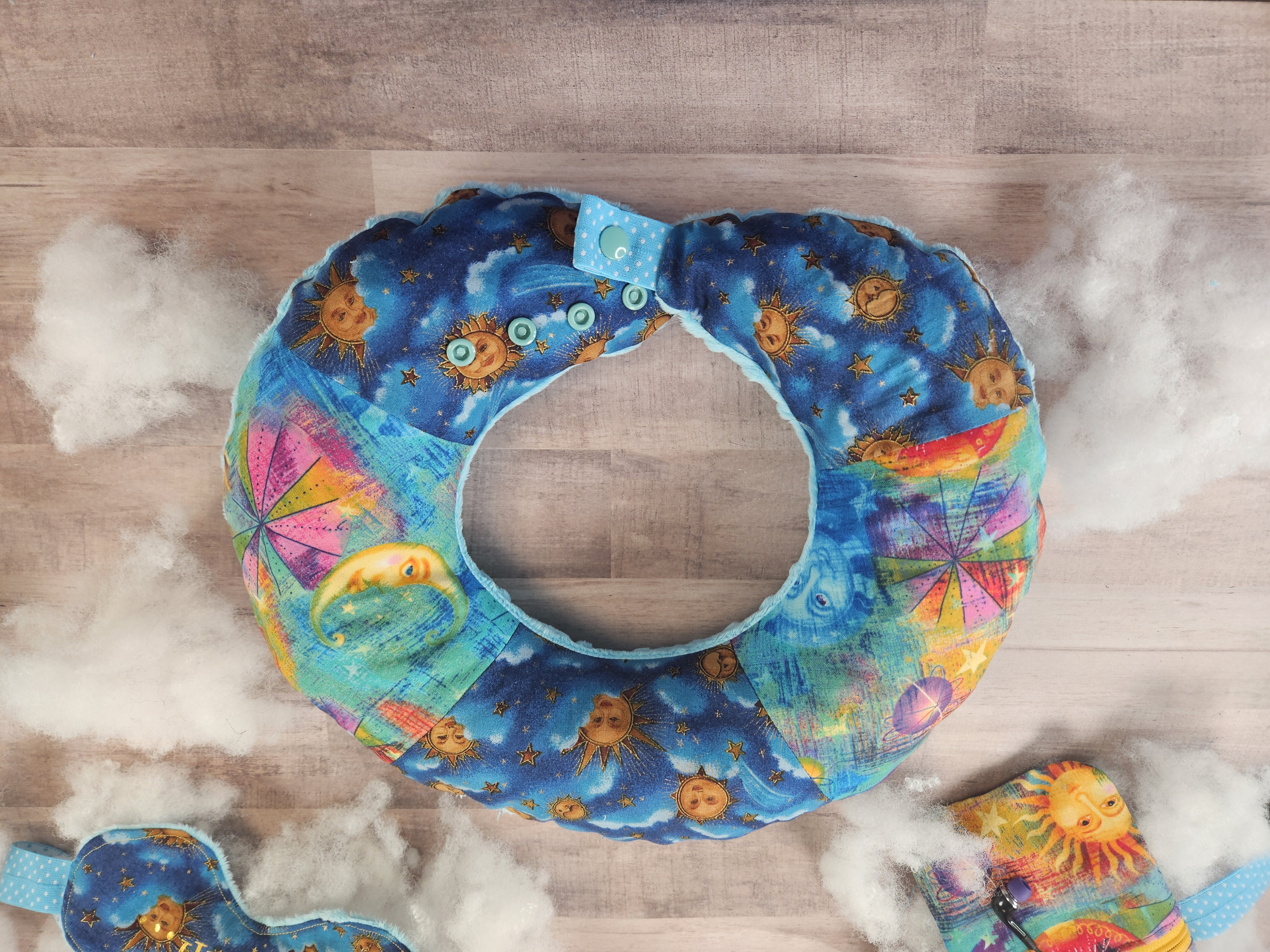 Travel neck pillow in blue celestial fabric with adjustable neck strap