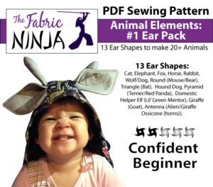 A toddler smiling big while wearing a giraffe hood. Animal elements Ear Pack. 13 ear shapes PDF sewing Pattern. Confident Beginner.