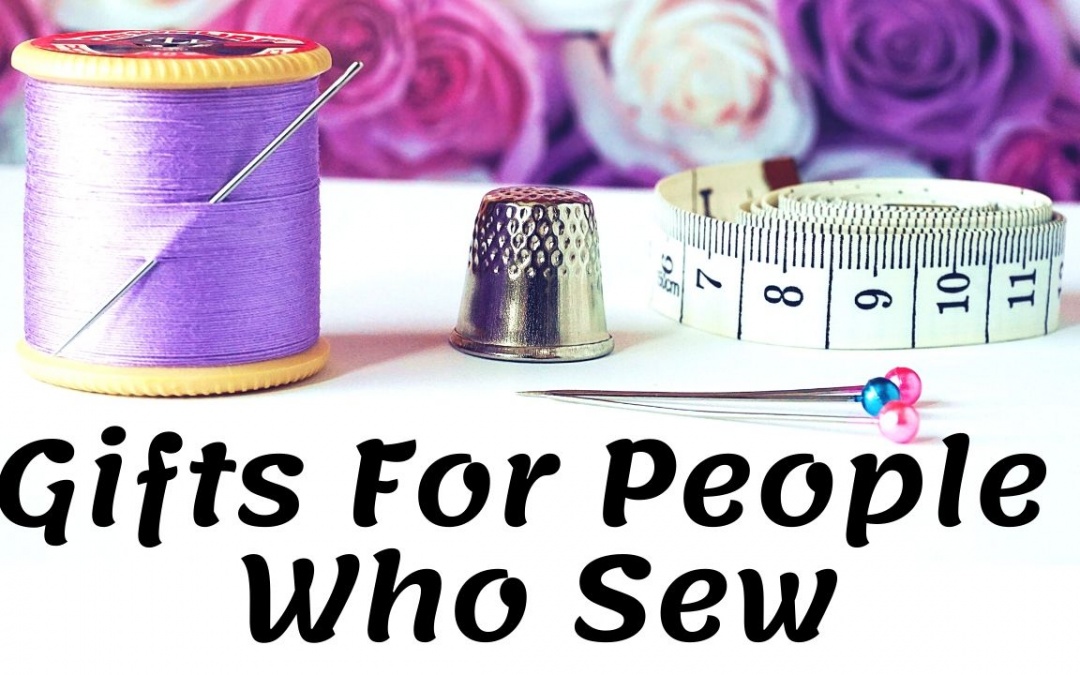 "Gifts for people who sew" Purple spool of thread, silver thimble, and white measuring tape.