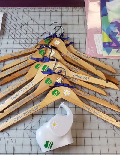 wooden hangers with girl scout symbols for retired daisy uniforms