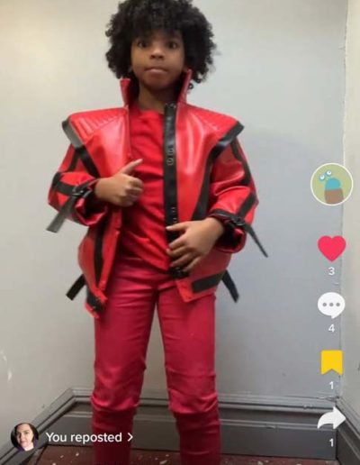 Red faux leather jacket with black V stripe pattern - reproduction Michael Jackson's thriller jacket - modeled on young black girl