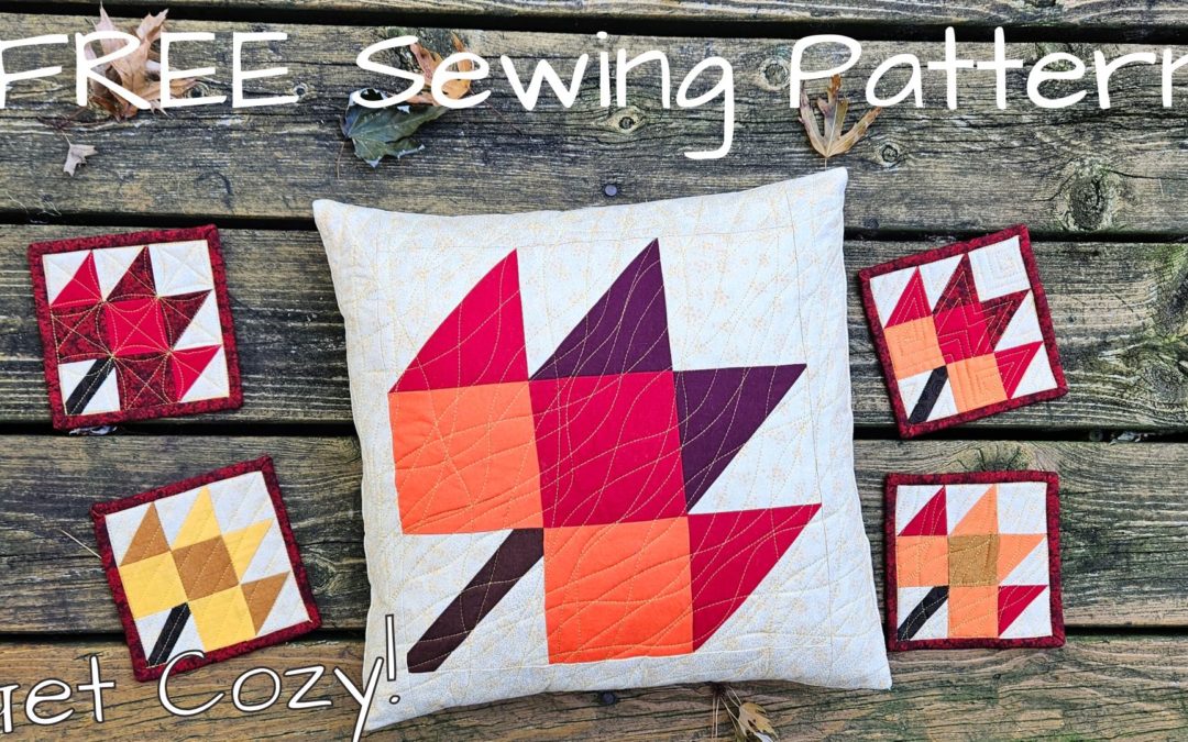 maple leaf quilted pillow on a grey brown wood background surrounded by smaller maple leaf quilted coasters "Free Sewing Pattern"