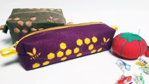 Purple and yellow pouch with bee cut work