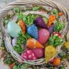 white wicker Easter basket filled with pastel plastic eggs and rainbow colored fabric carrots.