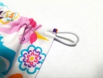 close up of white elastic loop on colorful fabric hood