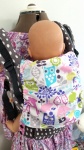 Babywearing sleeping hood in the down position. It is covered with colorful wildlife