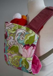 flower slipcover on pink onbuhimo happy baby carrier with red elmo doll inside