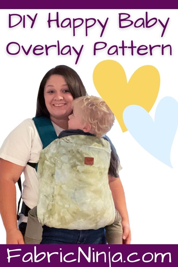 white woman with dark hair wearing blond haired baby in a happy baby toddler carrier with a green tie-dye slipcover