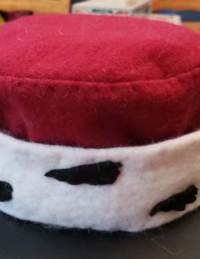 Cap of maintenance - red wool round cap with white brim and black wool bits to look like ermine