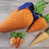 6 orange fabric carrots lined up in size from Jumbo to mini.
