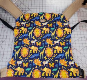 Happy baby toddler slipcover made withDark blue fabric with yellow safari animals like lions and giraffes.