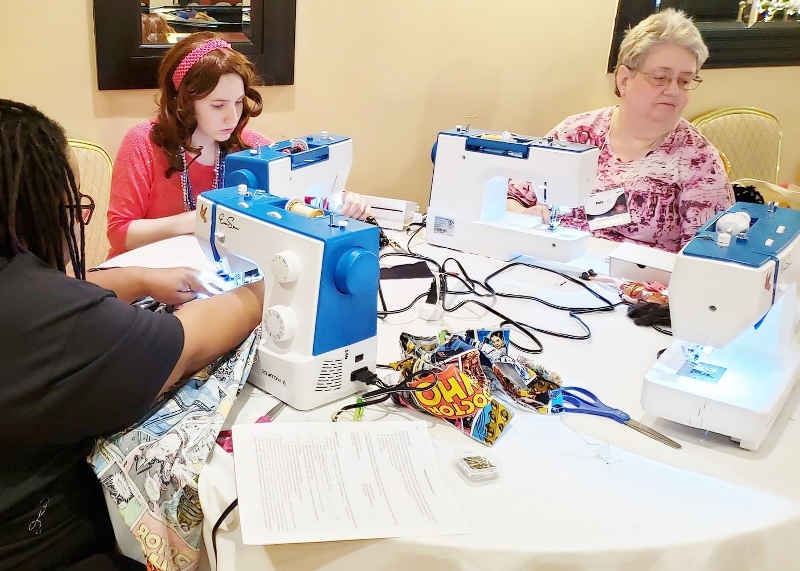 3 female students taking a sewing class using the EverSewn Sparrow 15 sewing machines
