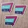 three stickers that say "Thanks! I Made It" in a 1960 sign style with arrow around one edge pointing down. Arrow is a warm purple, and the sign is aqua and dark blue with white writing