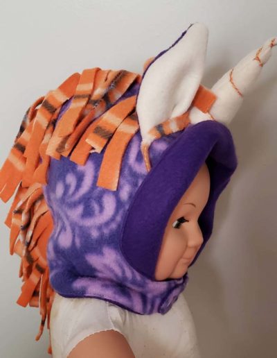 "Just add ears" and "Make it a unicorn" pack used to create a purple fleece hood with orange main and purple and white ears. Horn is white with orange swirl